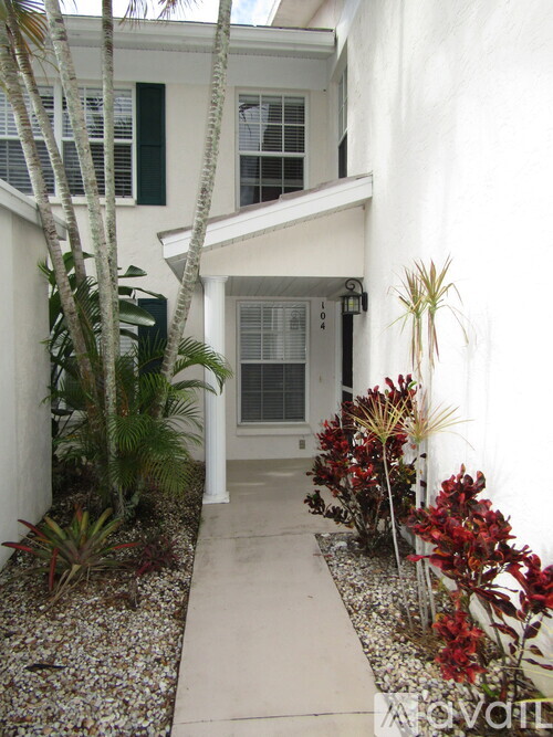 A white house with a small garden in front.