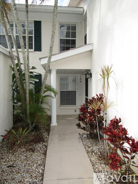 A white house with a small garden in front.