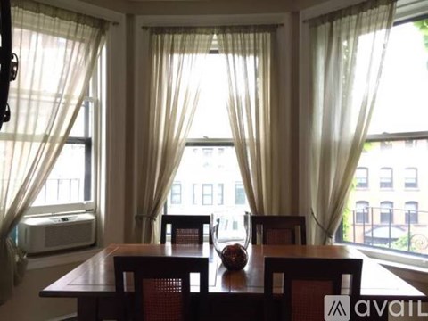 A dining room with a wooden table and chairs.