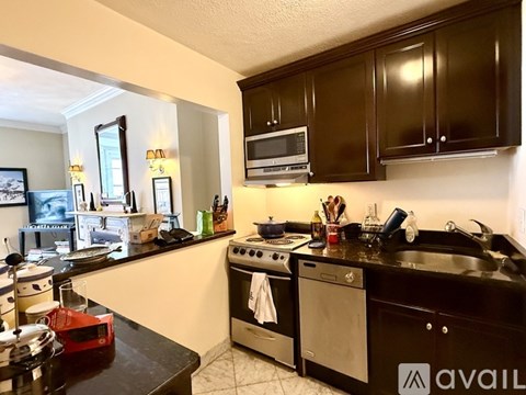 A kitchen with black cabinets and a stove top oven.