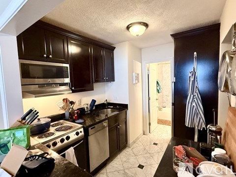 A kitchen with black cabinets and a stove top oven.