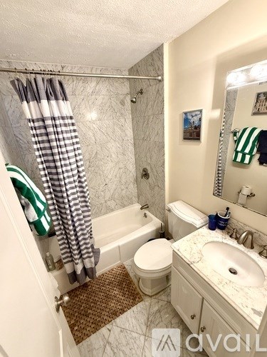 A bathroom with a toilet, sink, and shower.