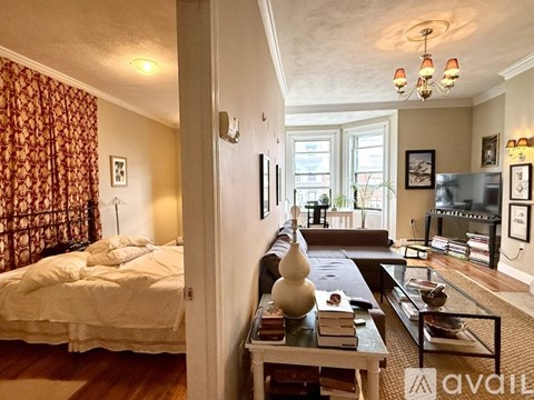 A living room with a brown leather couch and a fireplace.