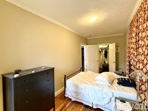 A bathroom with a toilet and a shower curtain.