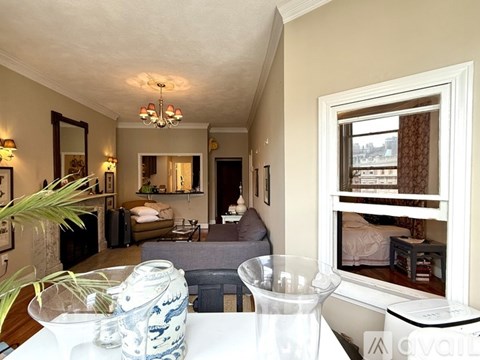 A living room with a grey couch and a white table.