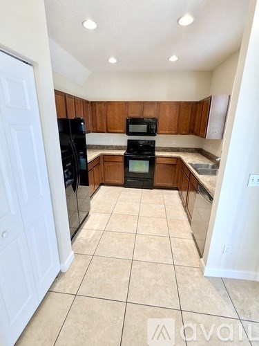 A kitchen with wooden cabinets and black appliances.