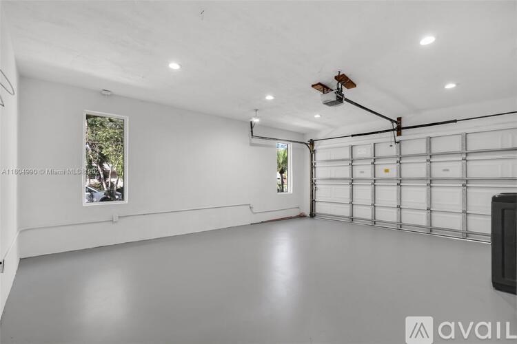 A spacious garage with a ceiling fan and a window.