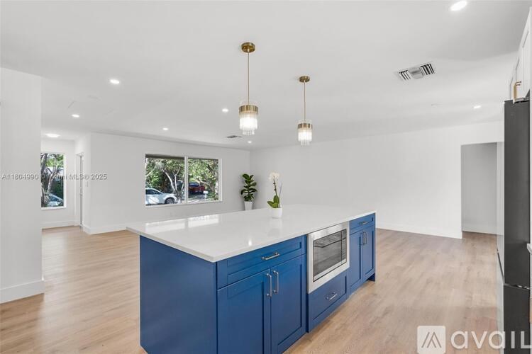A kitchen with blue cabinets and a white countertop.