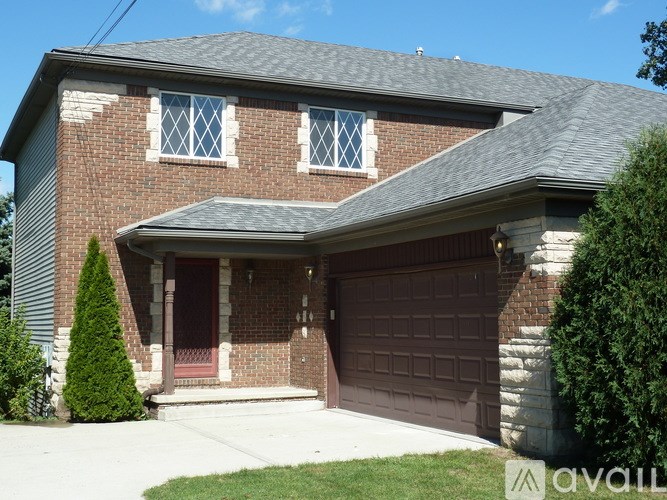 A house with a brick facade and a brown garage door.