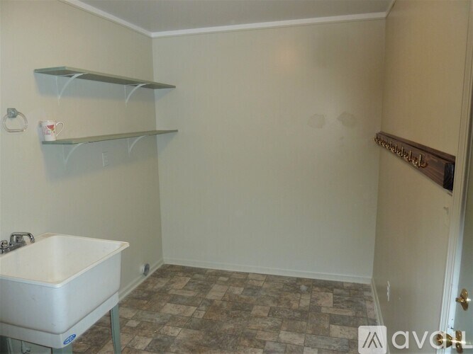 A small room with a sink and shelves.