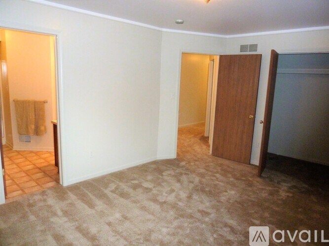 A room with a carpeted floor and a door on the right.