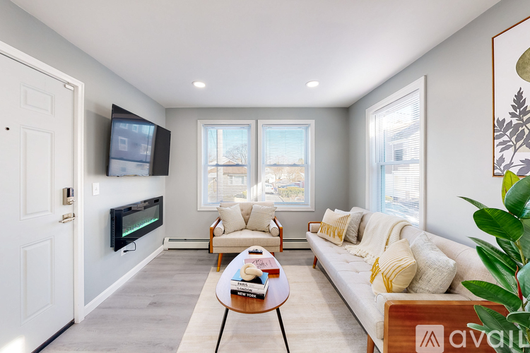 A living room with a couch, a chair, a coffee table, and a television.