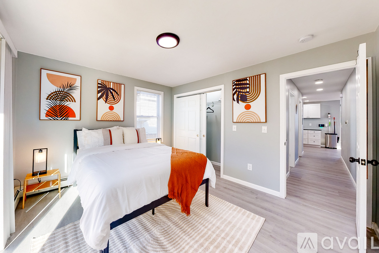 A bedroom with a large bed and artwork on the walls.