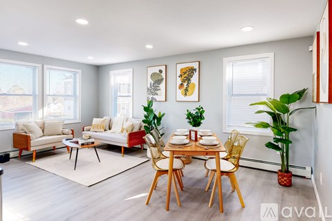A living room with a dining table set for two and a couch.