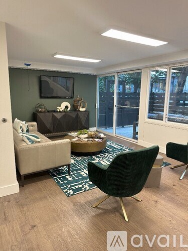 A living room with a green rug and a black chair.