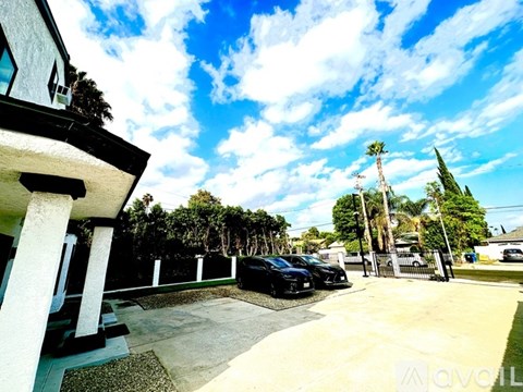 A black car is parked in a driveway.