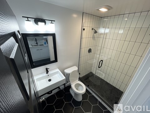 A bathroom with a toilet, sink, and mirror.