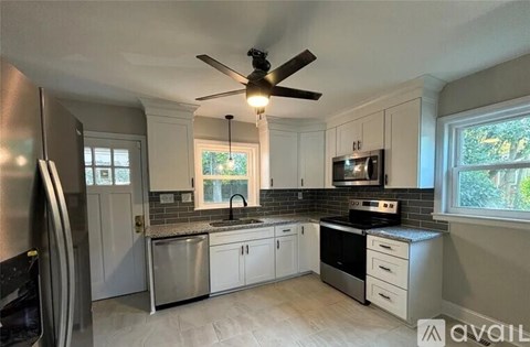 A kitchen with white cabinets and a black stove top oven.