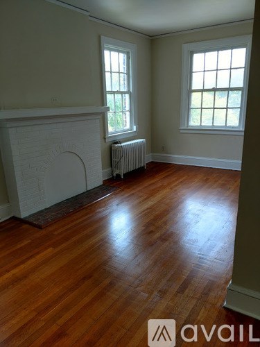 A room with a fireplace and wood floors.