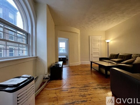 A living room with a couch and a window.