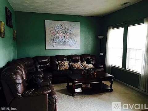 A living room with a brown leather couch and a coffee table.