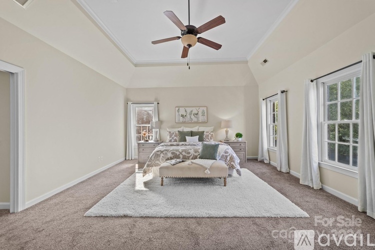 A bedroom with a bed, a dresser, and a ceiling fan.