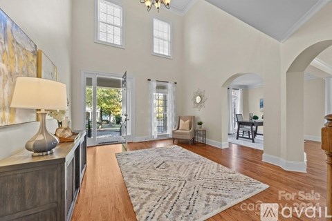 A living room with a rug on the floor and a lamp on the side table.