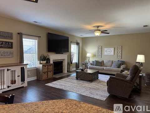 A living room with a fireplace and a television on the wall.