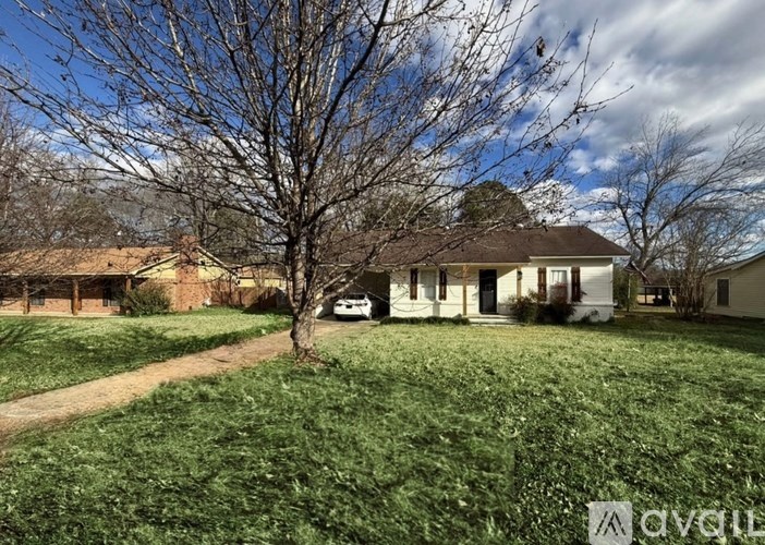 A white house with a tree in front of it.