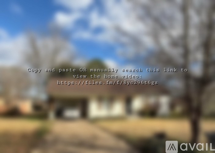 A blurry image of a house with a tree in front and a sky in the background.