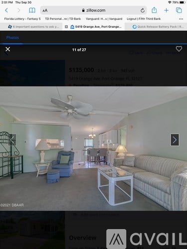 A living room with a white couch and a ceiling fan.