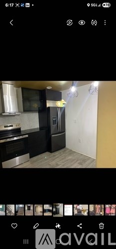 A modern kitchen with stainless steel appliances and wooden flooring.