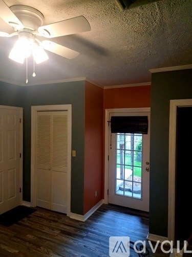 A room with a ceiling fan and a door leading outside.