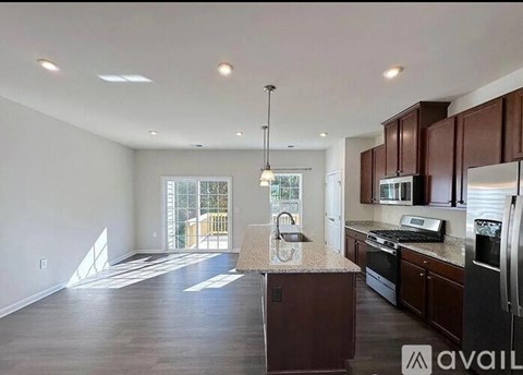 A kitchen with dark wood cabinets and a granite countertop.