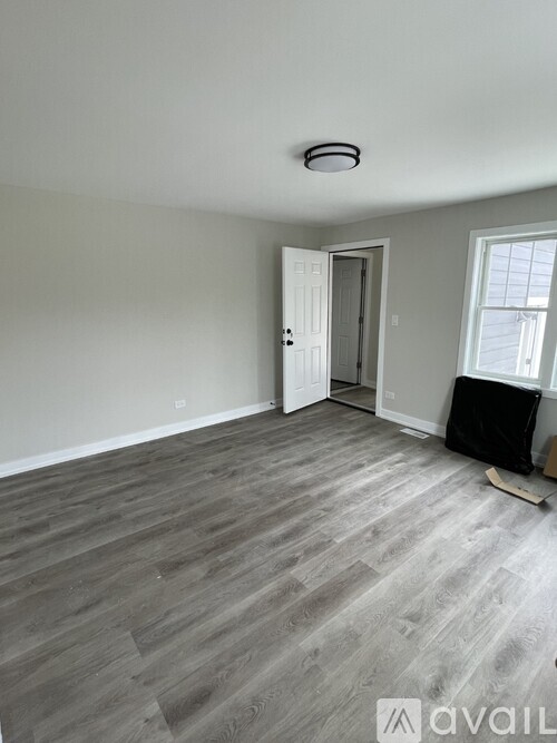 A room with a grey floor and a white door.