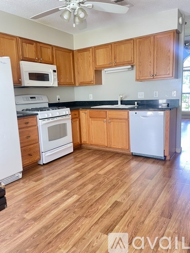 A kitchen with wooden cabinets and a white fridge.