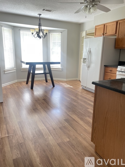 A kitchen with a table and a fan.