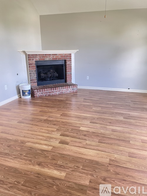 A room with a fireplace and wooden flooring.