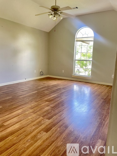 A room with wooden flooring and a ceiling fan.