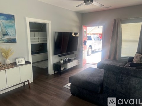 A living room with a black couch and a television.