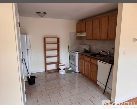 A kitchen with white appliances and wooden cabinets.