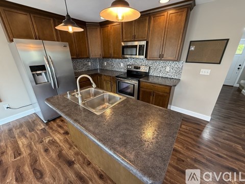 A kitchen with wooden cabinets and a granite countertop.
