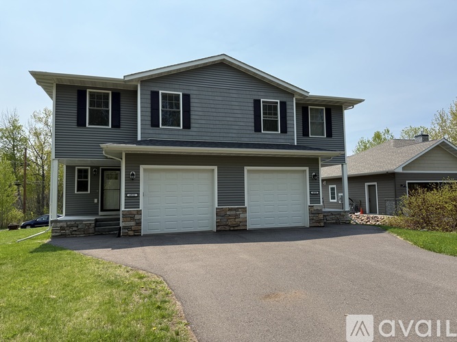 A two-story house with a garage is available for sale.