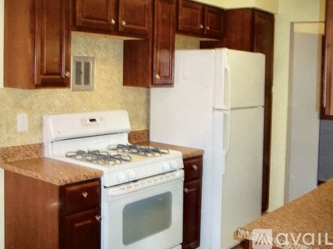 A kitchen with a white stove and a white refrigerator.