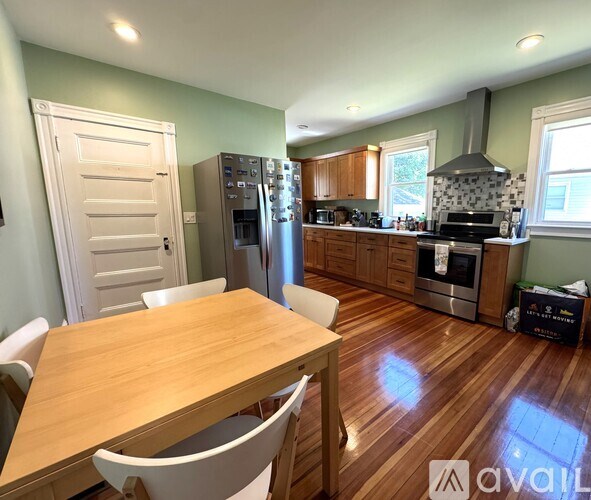 A kitchen with a wooden table and chairs.