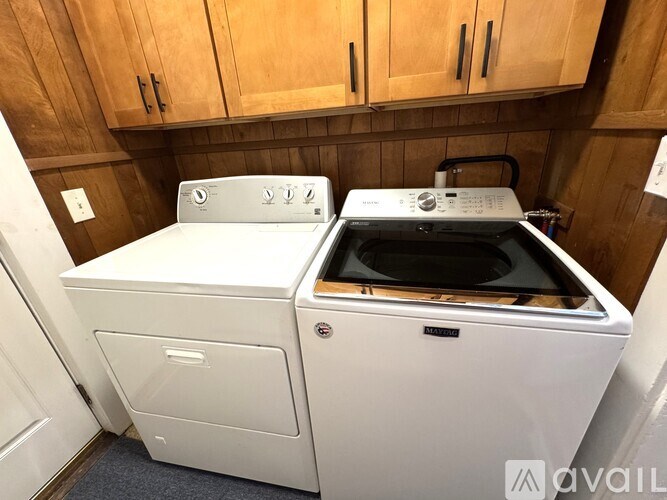 A white washing machine and dryer in a laundry room.