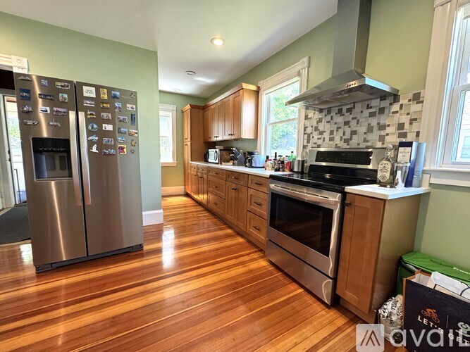 A kitchen with wood floors and stainless steel appliances.