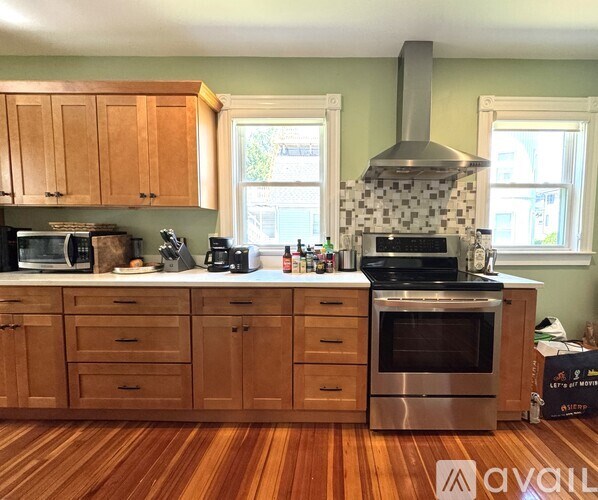 A kitchen with wooden cabinets and a stainless steel oven.