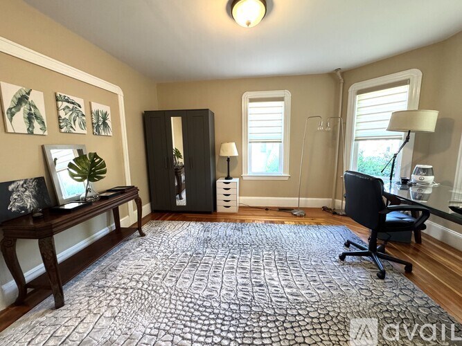 A room with a patterned carpet and a desk with a chair.