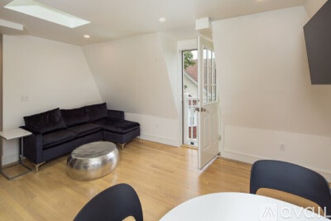 A living room with a black couch and a white table.